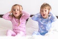 Two Preschool Toddler Children Siblings Boy And Girl portray horror surprise In Pink Blue Pajamas On White Bed. Little Royalty Free Stock Photo