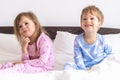 Two Preschool Toddler Children Siblings Boy And Girl Smiling Look At Side In Pink Blue Pajamas On White Bed. Little Baby Royalty Free Stock Photo