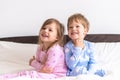 Two Preschool Toddler Children Siblings Boy And Girl Smiling Look At Side In Pink Blue Pajamas On White Bed. Little Baby Royalty Free Stock Photo