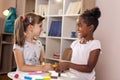 Schoolgirls playing with colorful plasticine