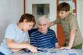 Two Preteen Boys Teaching Grandfather How to Use Internet Safely. Teenage Brothers, School Children with Digital Tablet Royalty Free Stock Photo