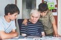 Two Preteen Boys Teaching Grandfather How to Use Internet Safely. Teenage Brothers, School Children with Digital Tablet Royalty Free Stock Photo