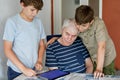 Two Preteen Boys Teaching Grandfather How to Use Internet Safely. Teenage Brothers, School Children with Digital Tablet Royalty Free Stock Photo