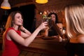 Two pretty Caucasian girls toasting drinking cocktails in pub celebrating birthday