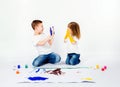 Two pretty child friends boy and girl are drawing pictures by paints. Showing hands in paint, sckream, roar, happy. Royalty Free Stock Photo