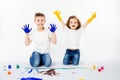 Two pretty child friends boy and girl are drawing pictures by paints. Showing hands in paint, sckream, roar, happy. Royalty Free Stock Photo