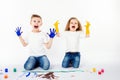 Two pretty child friends boy and girl are drawing pictures by paints. Showing hands in paint, sckream, roar, happy. Royalty Free Stock Photo