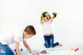 Two pretty child friends boy and girl are drawing pictures by paints. Showing hands in paint, sckream, roar, happy. Royalty Free Stock Photo