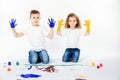 Two pretty child friends boy and girl are drawing pictures by paints. Showing hands in paint, sckream, roar, happy. Royalty Free Stock Photo