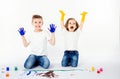 Two pretty child friends boy and girl are drawing pictures by paints. Showing hands in paint, sckream, roar, happy. Royalty Free Stock Photo