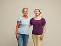 Two pretty old women friends on grey background. Royalty Free Stock Photo