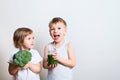 Two pretty fun kids with green smoothies and broccoli. Helthy an Royalty Free Stock Photo