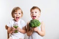 Two pretty fun kids with green smoothies and broccoli over white Royalty Free Stock Photo