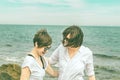 Two pretty girls on the beach smiling and looking at each other Royalty Free Stock Photo