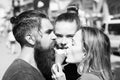 Two pretty girls and brutal, bearded man licking ice cream