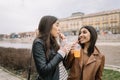 Two pretty girls drinking juice with straws next to river Royalty Free Stock Photo