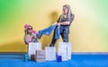 Two pretty girls are fighting over new clothes. Denim pants ripping open. There are shopping bags Royalty Free Stock Photo