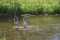 Two pretty girls at the river enjoy the waters and nature