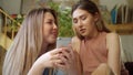 Two pretty lgbt girls are sitting on the sofa and chatting with their friends on the Internet, close up slow motion