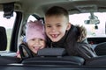 Two pretty little children boy and girl in a car interior Royalty Free Stock Photo