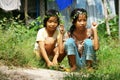 Two pretty little girls picking wild flower to make head wreath at grassland in summertime