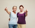 Two pretty older women friends on grey background. Royalty Free Stock Photo