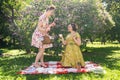 Two pretty pin up ladies having nice picnic in the city park in a sunny day together. girls friends enjoy hot summer weather. beau Royalty Free Stock Photo