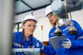 Two pretty professional technician or engineer women help to check the system use controller and ipad with robotic machine in