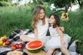 Two pretty sisters enjoying picnic during summertime