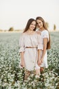 Two pretty sisters in a field of flowers. Spring beauty concept. Portrait shot of two gorgeous women. Beautiful joyful two girls Royalty Free Stock Photo