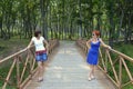 Two pretty sisters with sunglasses looking at each other on the wooden footbridge
