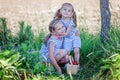 Two pretty sisters 3 and 7 years old picking strawberries at the farm