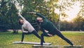 Two pretty women are doing yoga outdoors in park on mats practising asanas and breathing fresh air. Individual practice Royalty Free Stock Photo