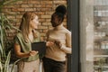 Two young business women with digital tablet standing by the brick wall in the industrial style office Royalty Free Stock Photo