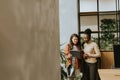 Two young business women with digital tablet standing in the modern office Royalty Free Stock Photo