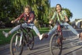 Two pretty young caucasian girls having fun on bicycles along the street. Best friends enjoying a day on bikes. Sunny summer