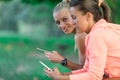 Two Pretty young woman in sporty outfit using a smartphone Royalty Free Stock Photo