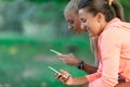 Two Pretty young woman in sporty outfit using a smartphone Royalty Free Stock Photo