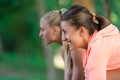 Two Pretty young woman in sporty outfit using a smartphone Royalty Free Stock Photo