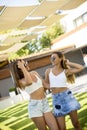 Two pretty young women posing in courtyard at hot summer day