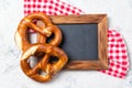Two pretzels on a checkered towel and chalkboard, beer snack, top view with copy space Royalty Free Stock Photo