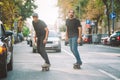 Two pro skateboard rider ride skate through cars on street