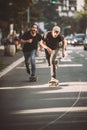 Two pro skateboard rider ride skate through cars on street