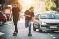 Two pro skateboard rider ride skate through cars on street