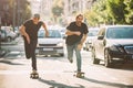 Two pro skateboard rider ride skate through cars on street