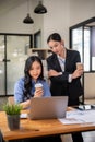 Two professional Asian businesswomen are working and examining a project on the laptop Royalty Free Stock Photo