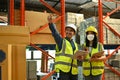 Two professional Asian warehouse workers are talking and discussing work in the warehouse Royalty Free Stock Photo