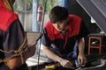 Two automotive mechanical partners check an EV car at a fixing garage.