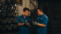 Two professional car mechanic using paperwork makes the oil and engine check to the car on lifted automobile at repair service
