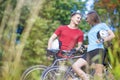 Two Professional Cycling Athletes Standing Together Outdoors wit